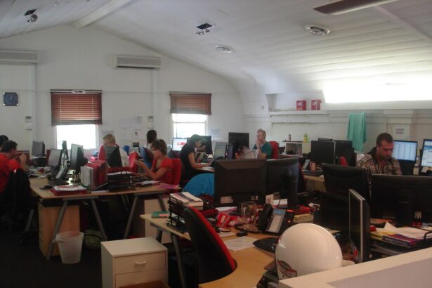 Office workers collaborate around a table as charts suggest steady business growth.