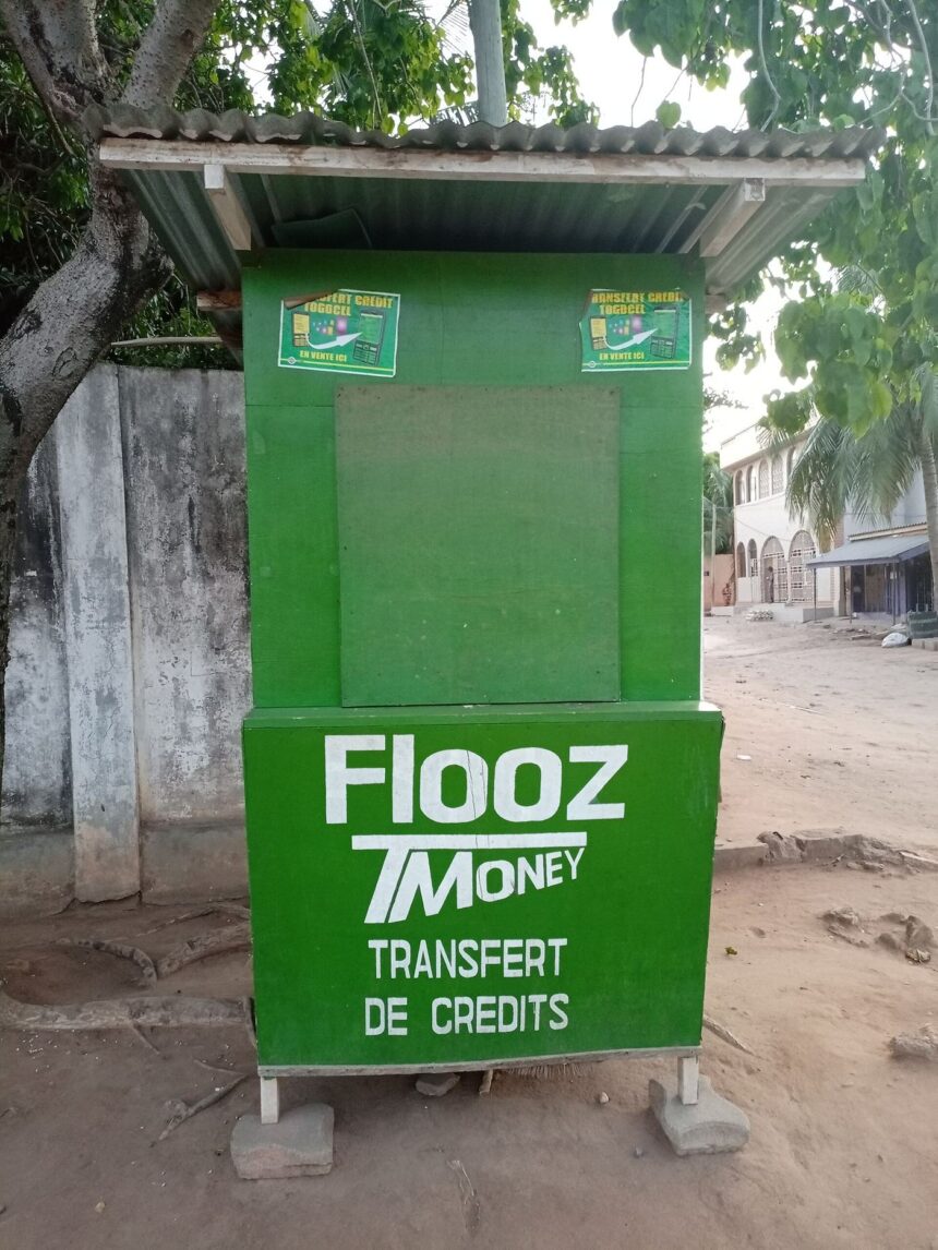 A market vendor in Africa using a mobile phone to take payment